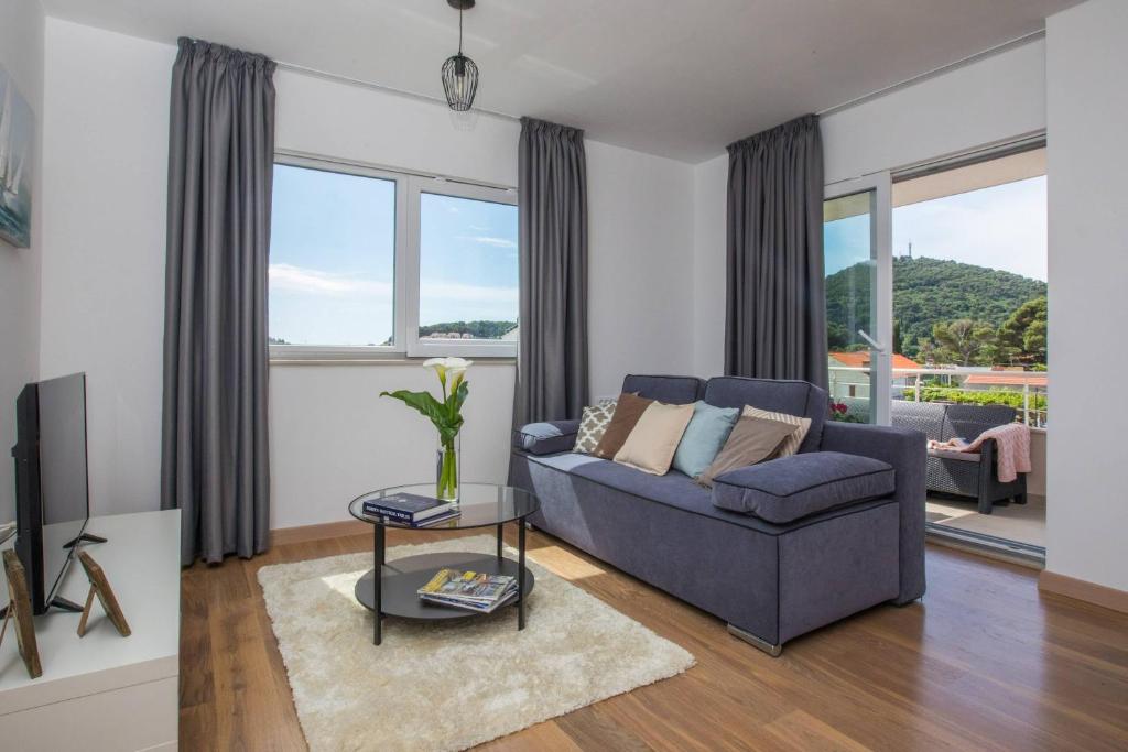 uma sala de estar com um sofá e uma mesa em Apartment Navis em Dubrovnik