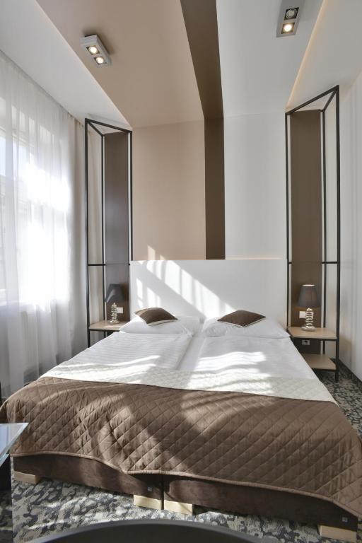 a bedroom with a large bed with white sheets at Máchova in Prague