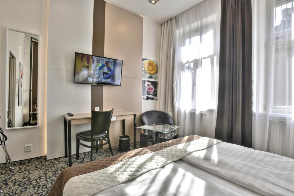 a hotel room with a bed and a table and chair at Máchova in Prague