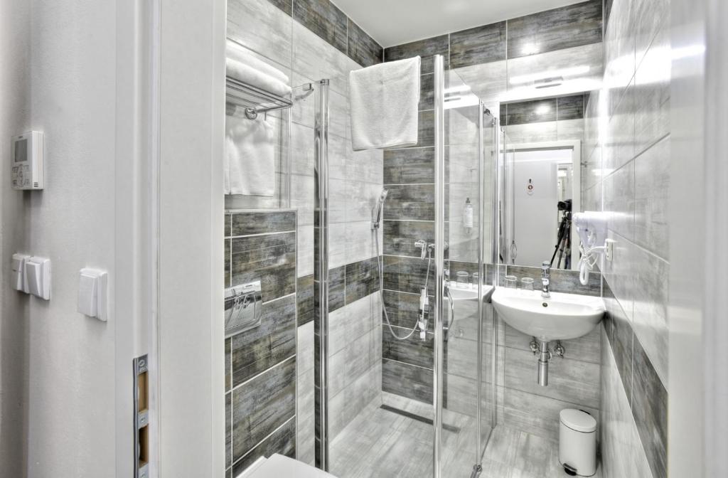 a white bathroom with a sink and a shower at Máchova in Prague