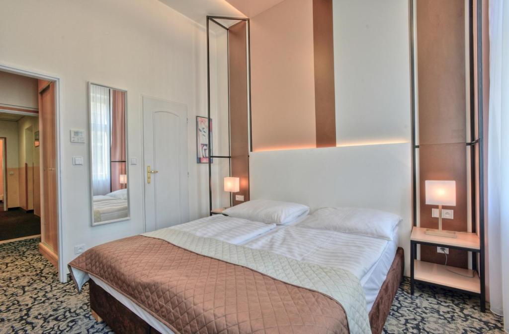 a bedroom with a bed and a mirror on the wall at Máchova in Prague