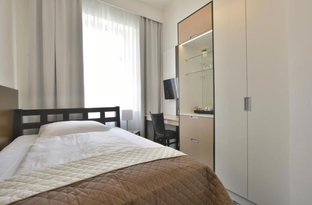 a bedroom with a bed and a dresser and a window at Máchova in Prague