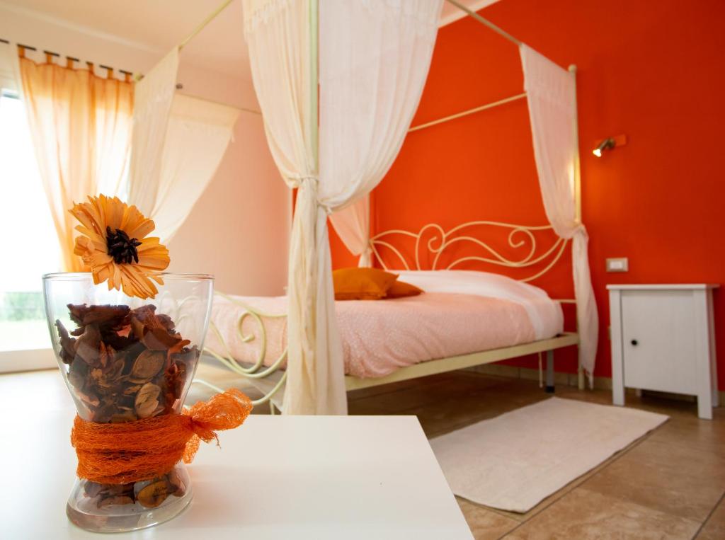 a bedroom with a bed and a vase with a flower in it at Villa Liburnia in Livorno
