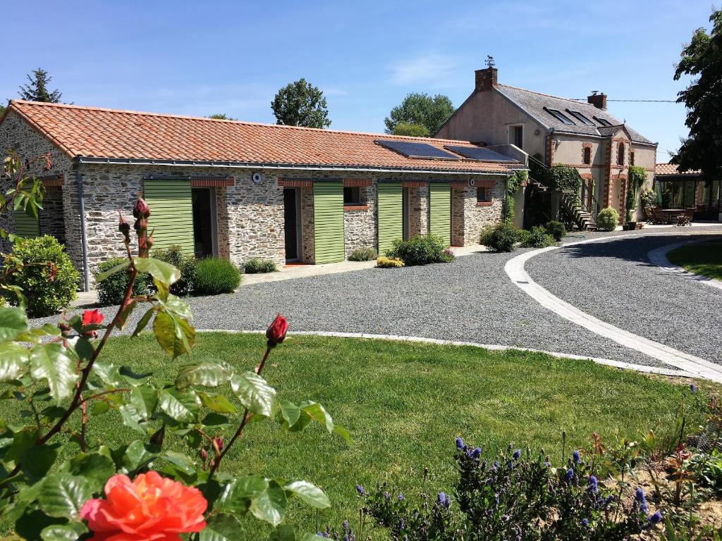 a house with a driveway in front of a yard at La Belle Verte in Pornic