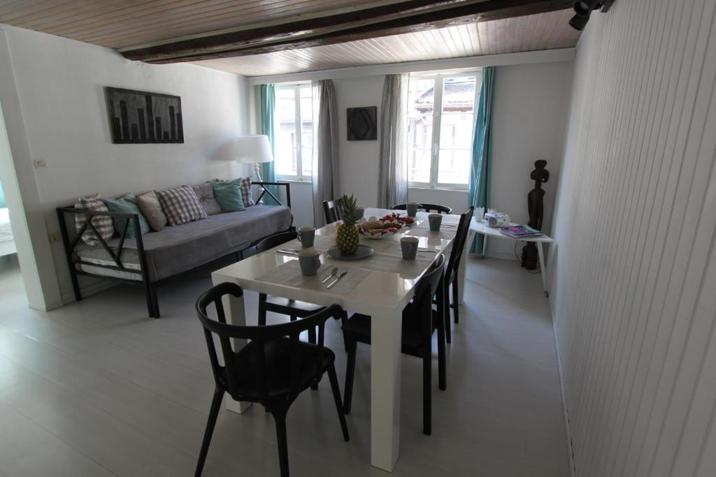 a living room with a table and chairs and a couch at Entre douceur et délicatesse in Colmar