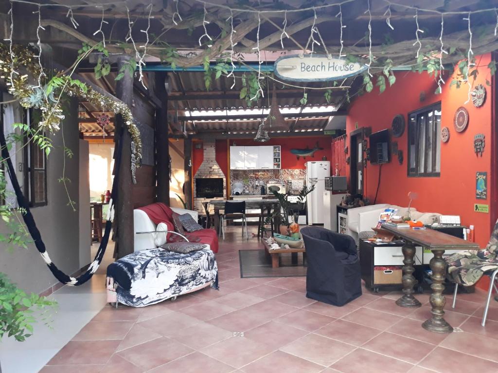 ein Wohnzimmer mit roten Wänden, einem Tisch und Stühlen in der Unterkunft Floripa Beach House Hostel in Florianópolis