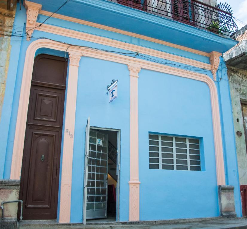 a blue building with a door and a balcony at Hostal Corona in Havana
