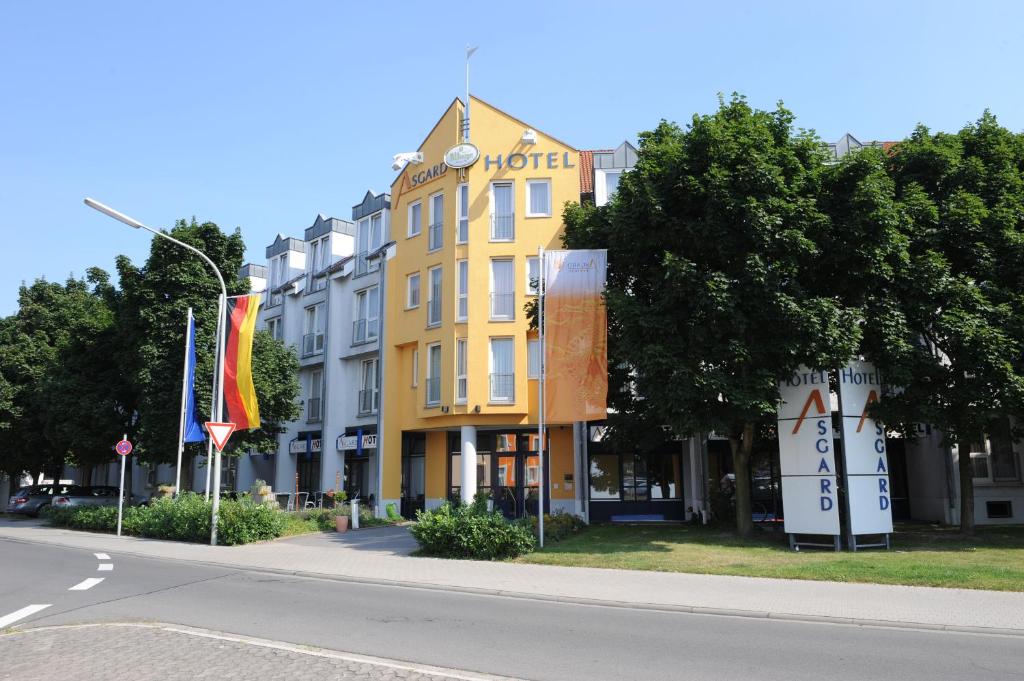 ein gelbes Gebäude an der Straßenseite in der Unterkunft Asgard Hotel in Worms