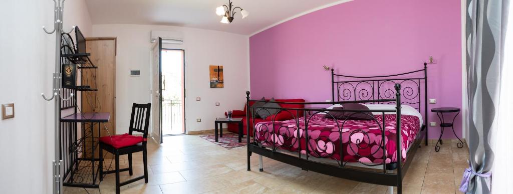 a bedroom with a bed with a pink wall at Villa Liburnia in Livorno