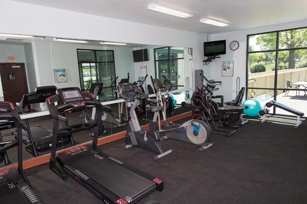 a gym with several treadmills and exercise machines at Rogue Regency Inn & Suites in Medford