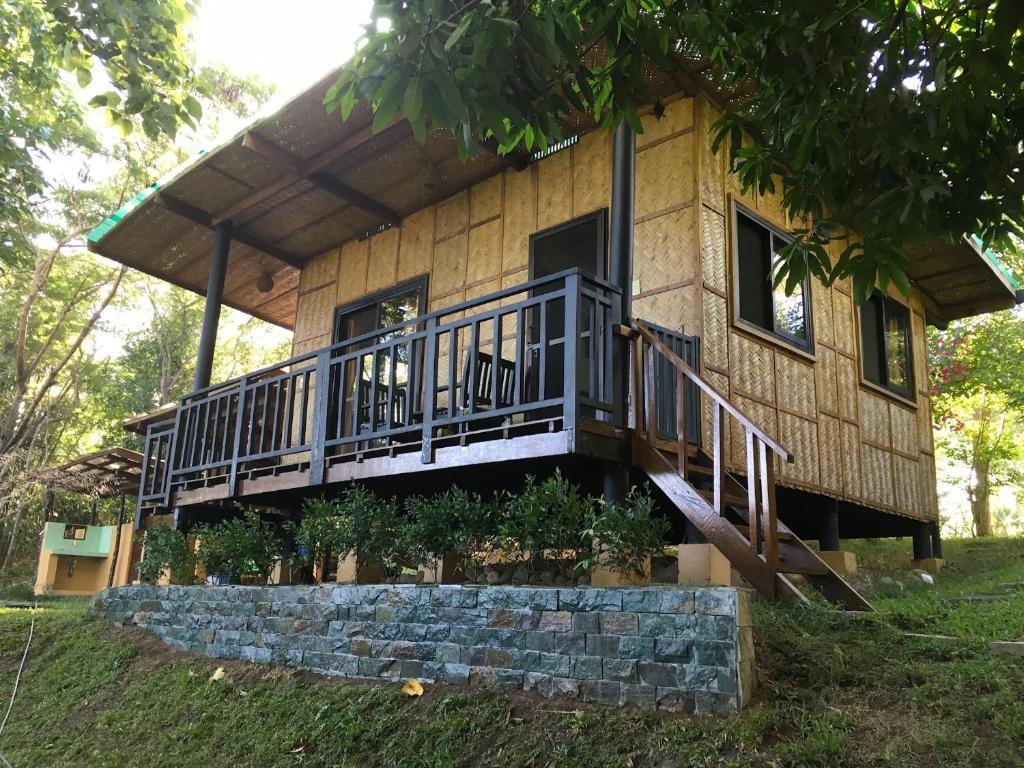 a house with a porch and a staircase on it at Native House with beautiful pool in Bagac