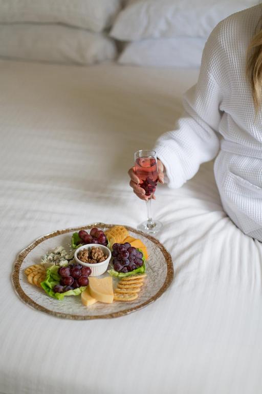 a woman with a plate of food and a glass of wine at Rogue Regency Inn & Suites in Medford