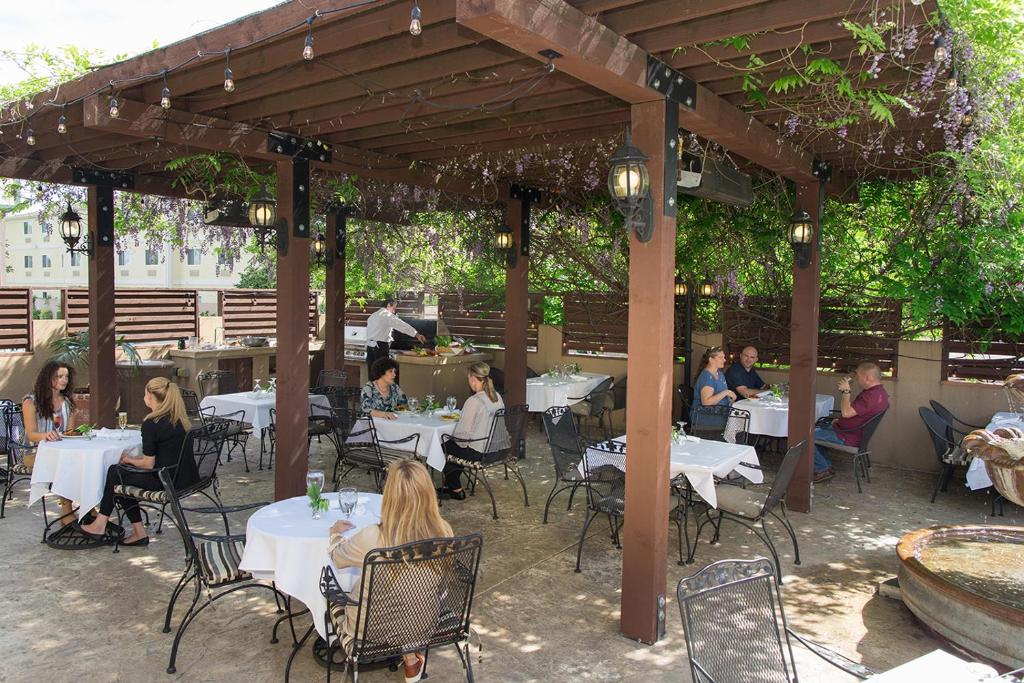 a group of people sitting at tables in a patio at Rogue Regency Inn & Suites in Medford