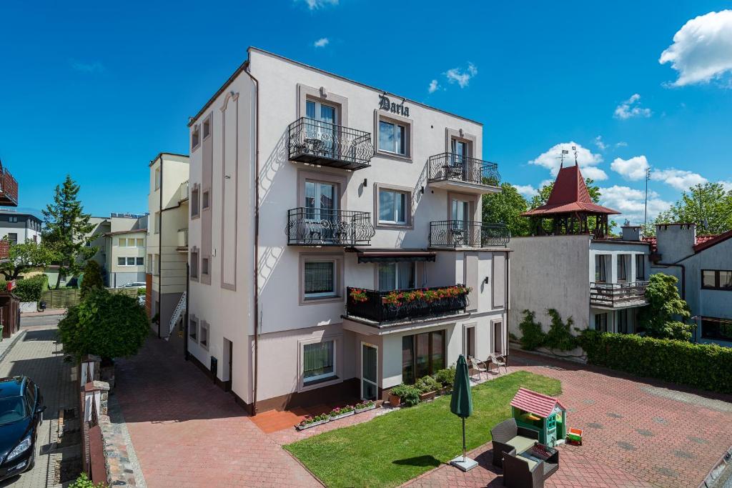 a large white building with balconies on a street at Willa Daria in Władysławowo