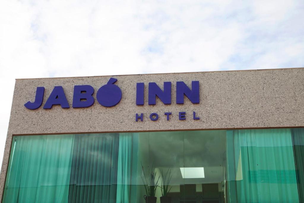 uma placa de hotel jba Inn no topo de um edifício em Jabó Inn Hotel em Jaboticatubas