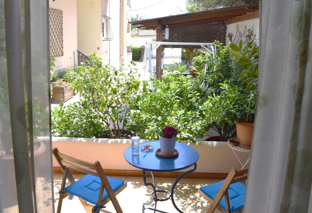 a table and chairs on a balcony with plants at Violet Bedroom and Apartment in Spata