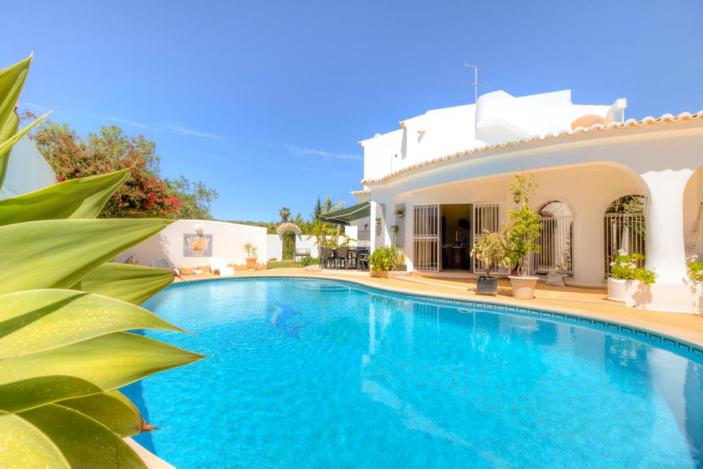 a swimming pool in front of a house at Villas2go2 V5 Vilamoura XXI in Vilamoura
