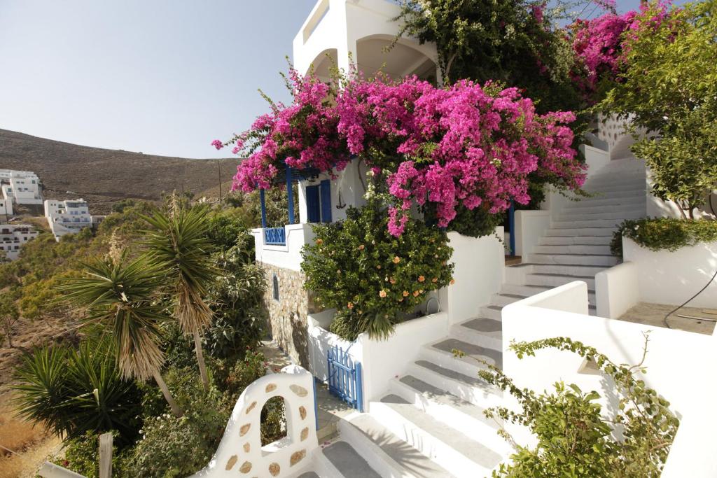 a white building with pink flowers on it at Butterfly View House in Astypalaia Town