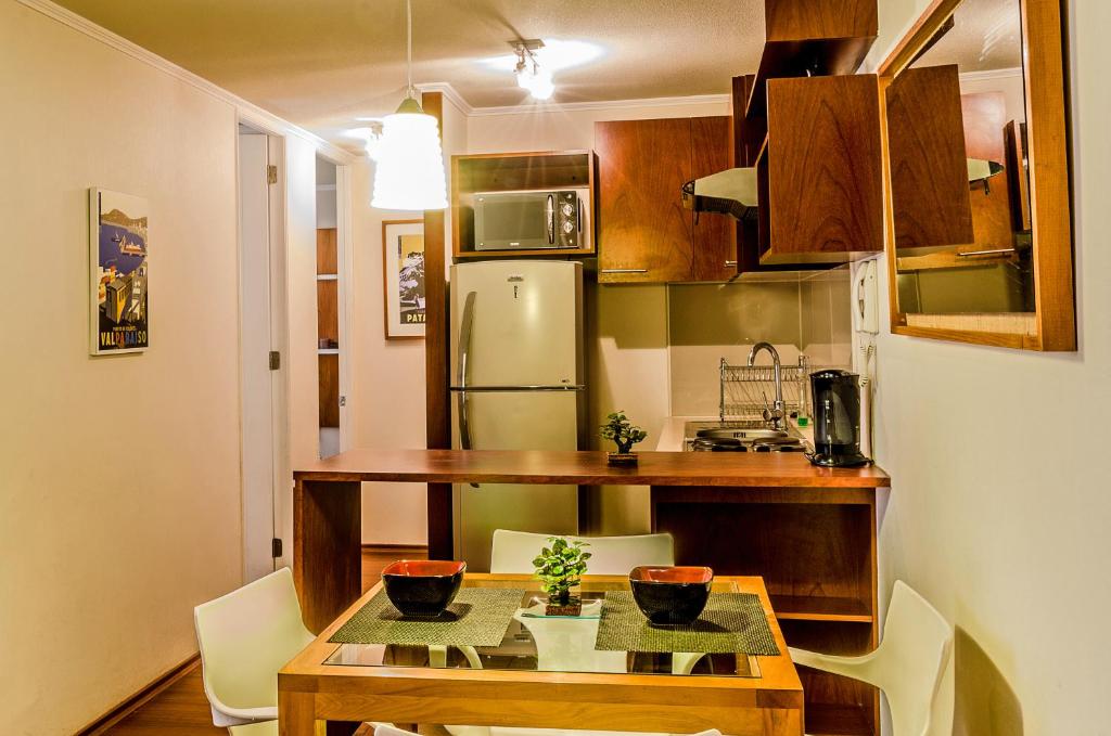 Il comprend une petite cuisine équipée d'une table et d'un réfrigérateur. dans l'établissement Departamentos Alto Moneda, à Santiago