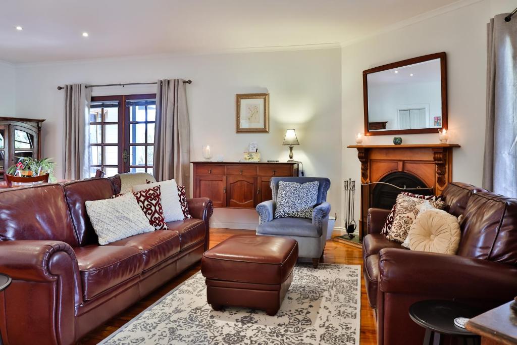 a living room with leather furniture and a fireplace at Parker Lodge Maldon in Maldon
