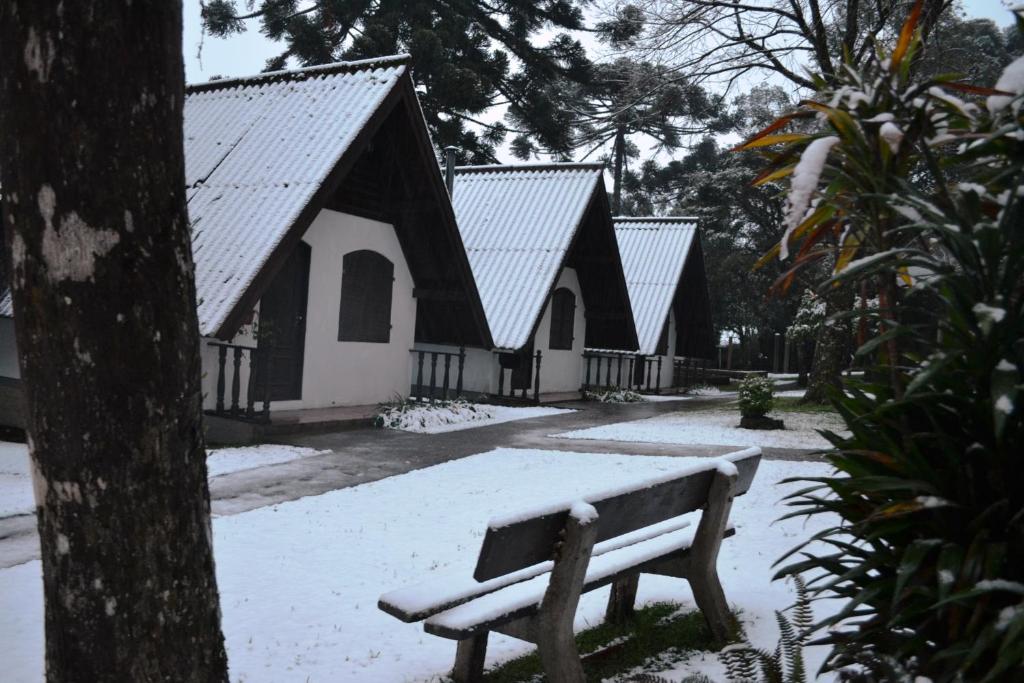 een bank in de sneeuw voor een kerk bij Hotel Pousada Dos Pinheiros in Canela