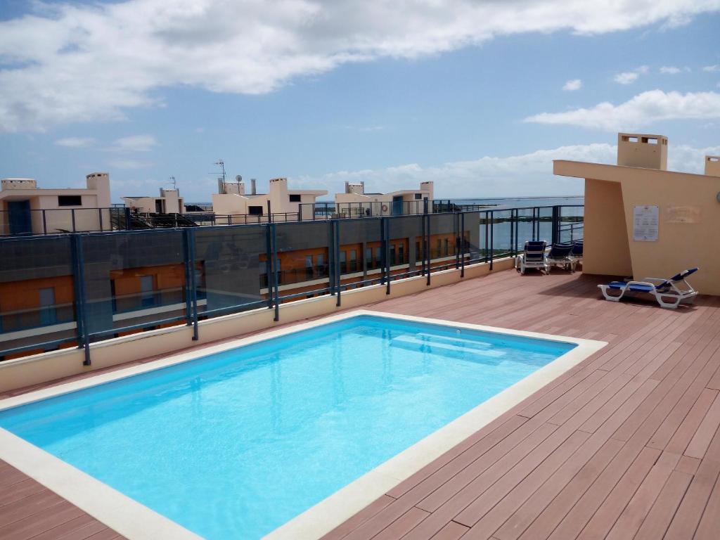a swimming pool on the roof of a building at Fun & Sun Apartment in Olhão