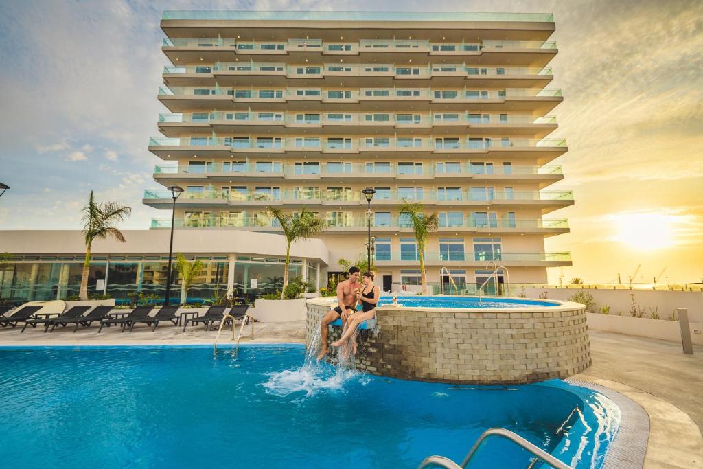 a man is swimming in a swimming pool at Antay Hotel & Spa in Arica