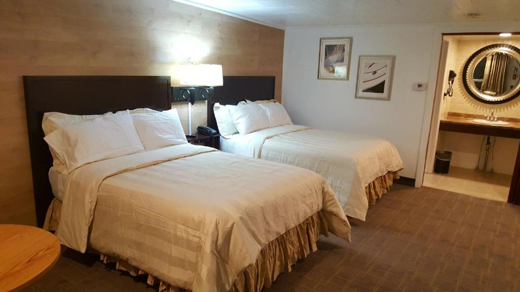 a hotel room with two beds and a table at Stucco Lodge in Bangor