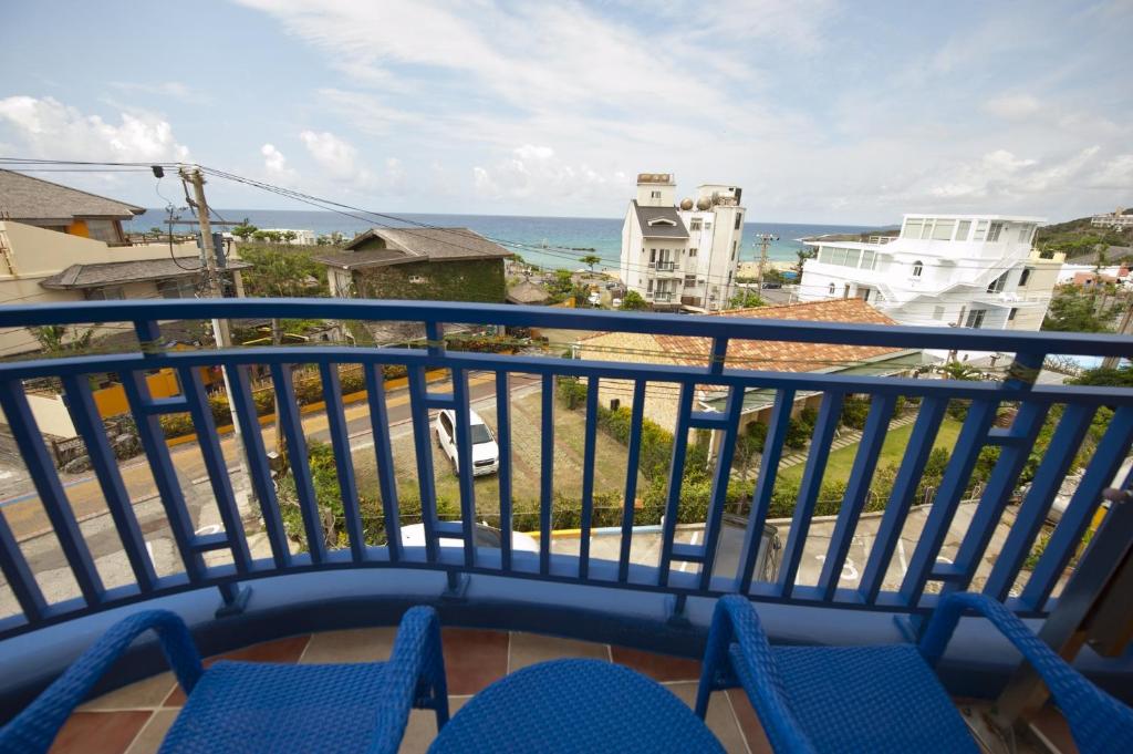 a balcony with chairs and a view of the ocean at Haisu Homestay in Eluan
