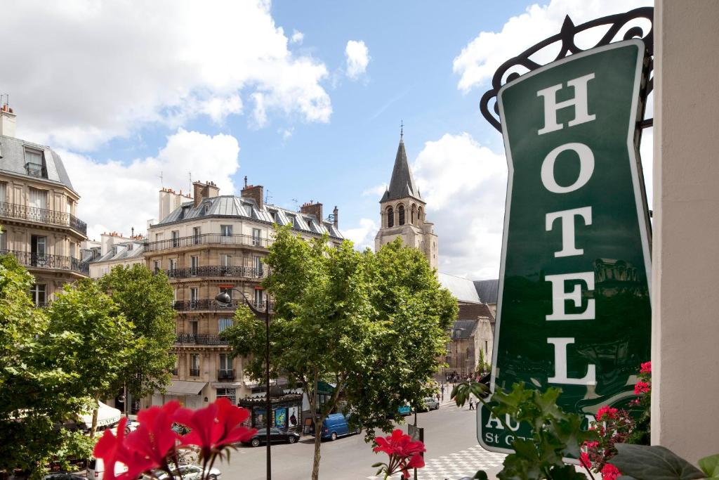 a sign for a hotel in a city with buildings at Au Manoir Saint Germain in Paris
