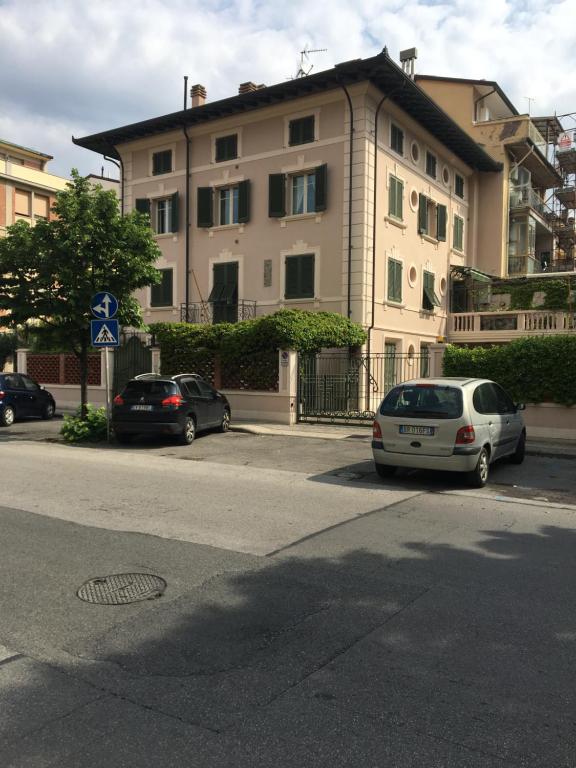due auto parcheggiate di fronte a un edificio di Seaside Idyll a Viareggio