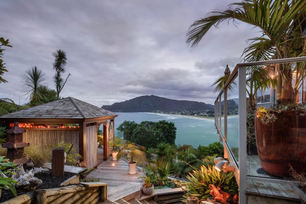 a garden with a gazebo and a view of the ocean at Paku Palms in Tairua