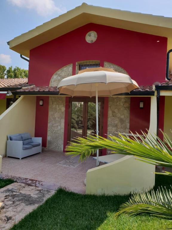 a red house with an umbrella in front of it at Su Soi in Càbras