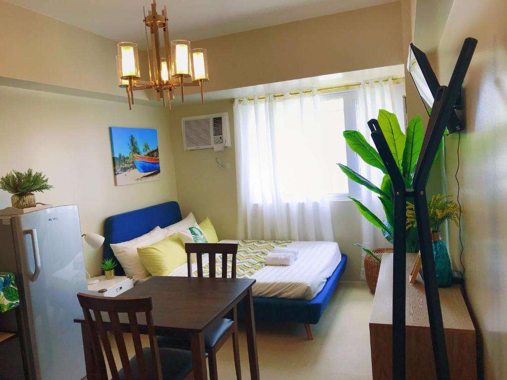a small room with a bed and a table and chairs at Davao Boutique Condos - Avida in Davao City