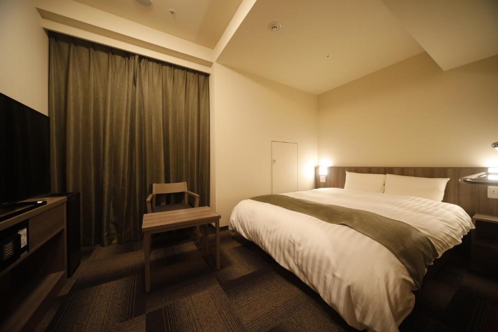 
A bed or beds in a room at Dormy Inn Korakuen
