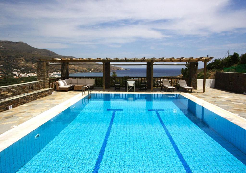 a swimming pool with a view of the ocean at Nicolas in Órmos