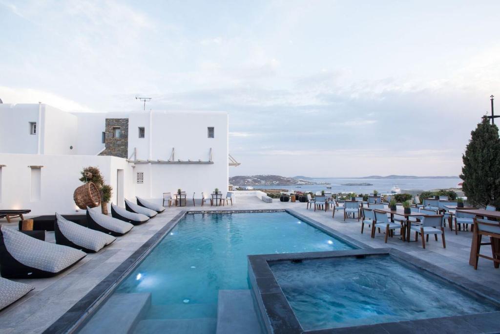 a pool with chairs and tables on a resort at Aletro Cottage Houses in Mikonos