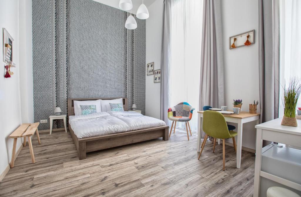 a bedroom with a bed and a desk and chairs at Budapest Passage 1 in Budapest