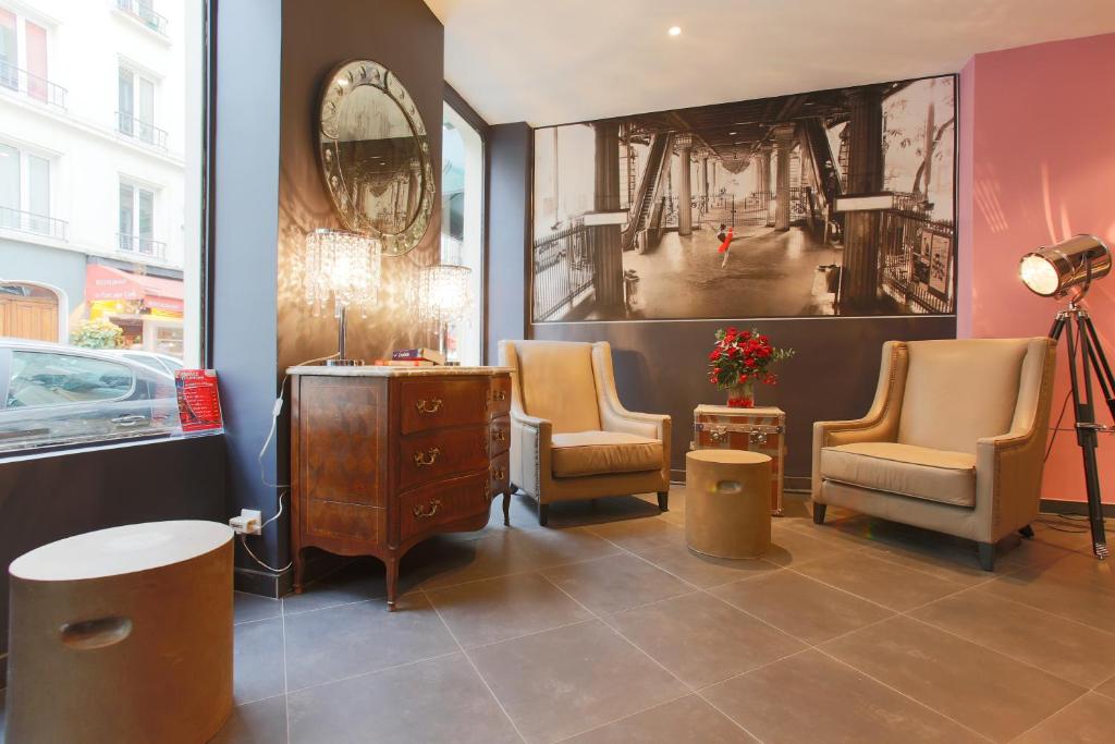 a salon with two chairs and a desk and a mirror at Hotel Atelier Vavin in Paris