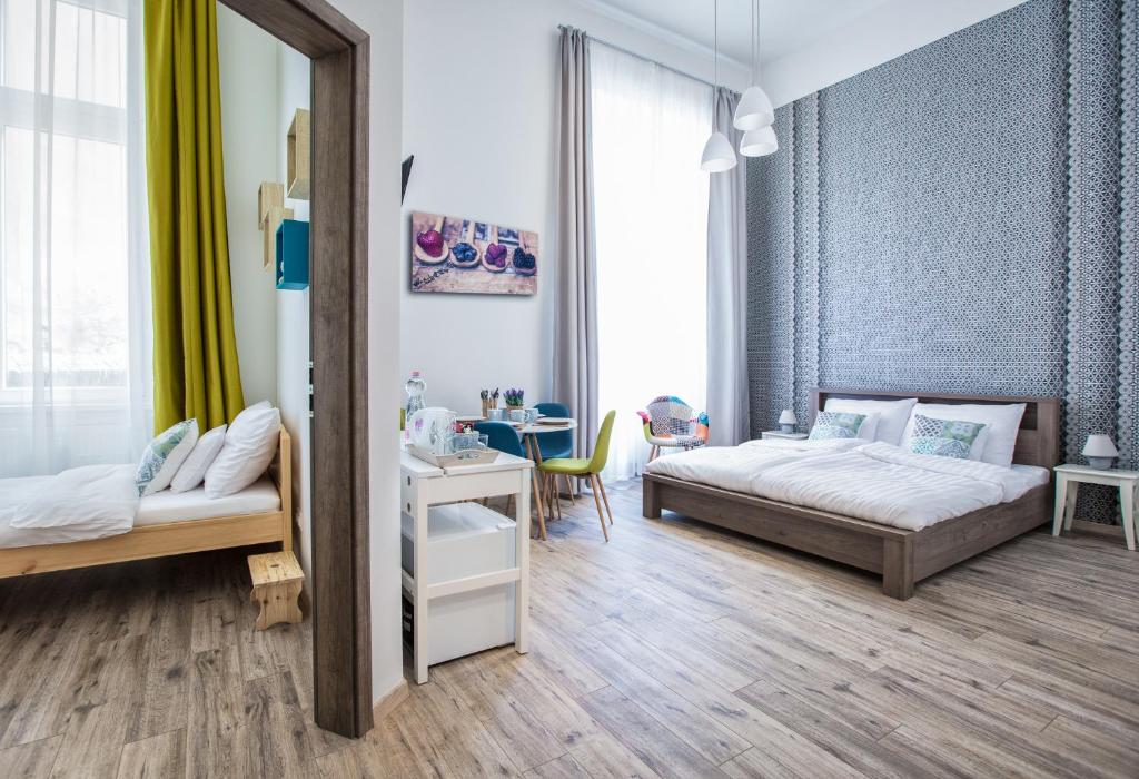 a bedroom with two beds and a table and a mirror at Budapest Passage 2 in Budapest