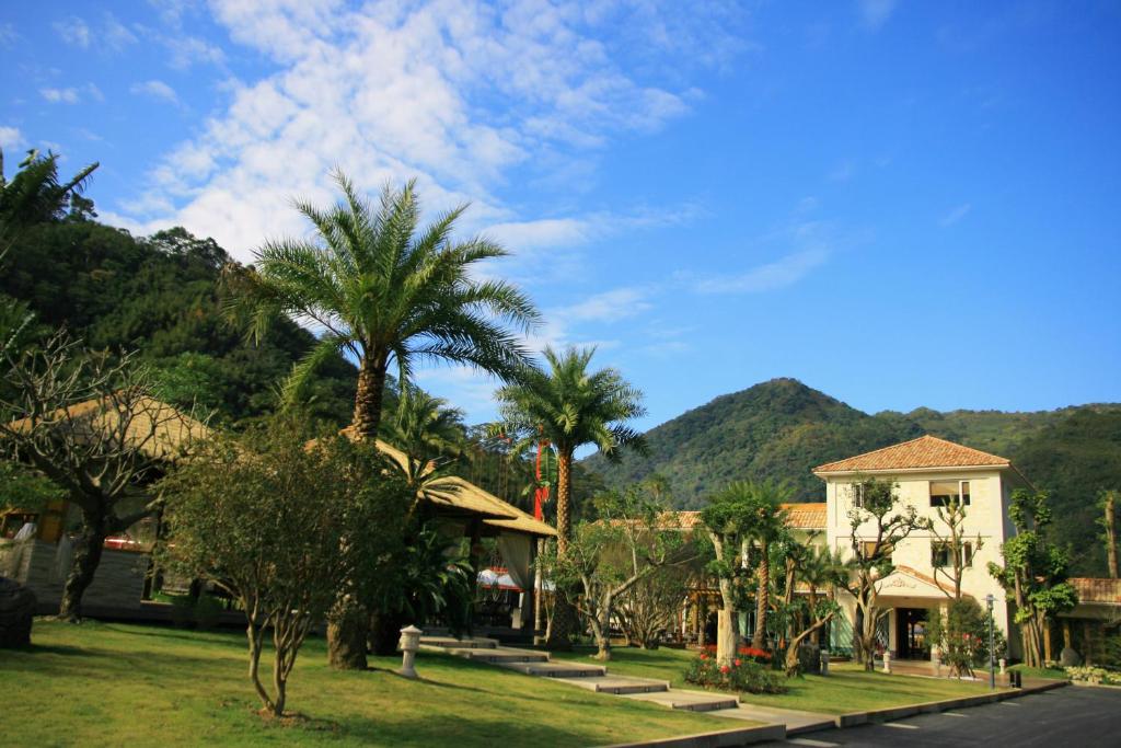 una casa con palmeras al lado de una calle en Hui-Lai Resorts en Jianshi