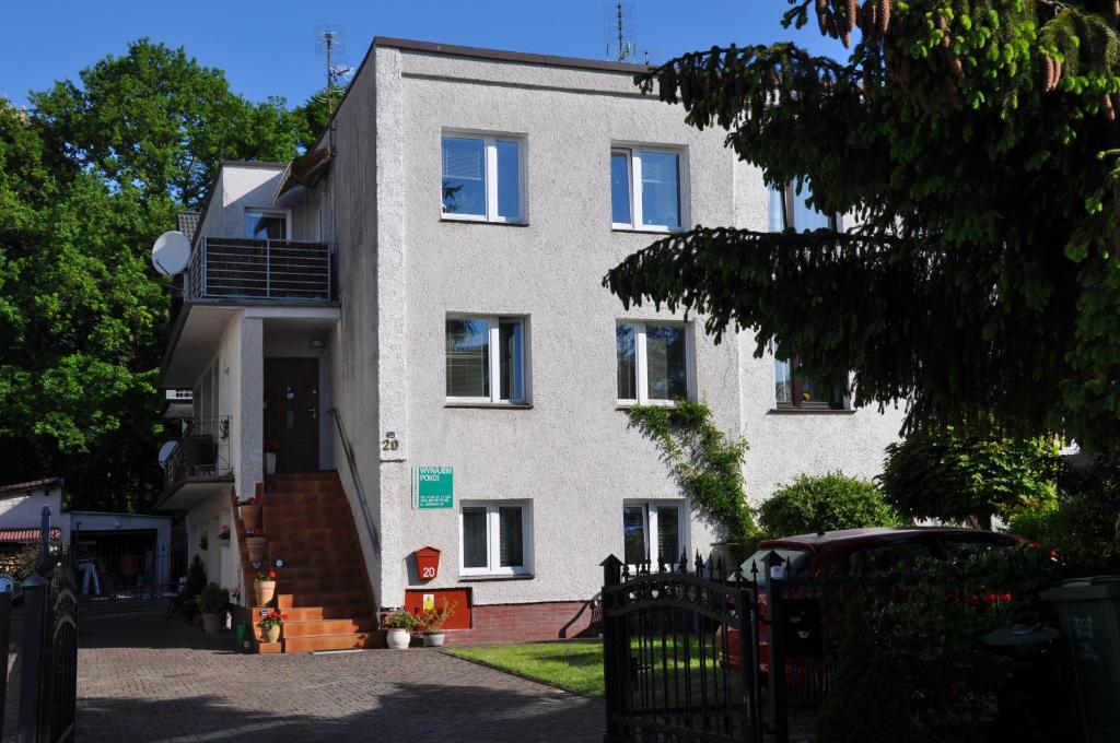 a white building with a staircase in front of it at J&T Pokoje Wczasowe in Kołobrzeg