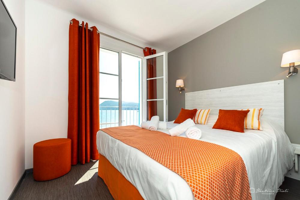 a bedroom with a large bed and a window at Hôtel George Sand in La Seyne-sur-Mer
