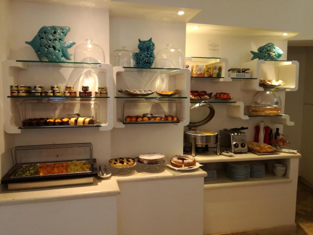a display case with various pastries and food on shelves at Hotel Orsa Maggiore in Anacapri