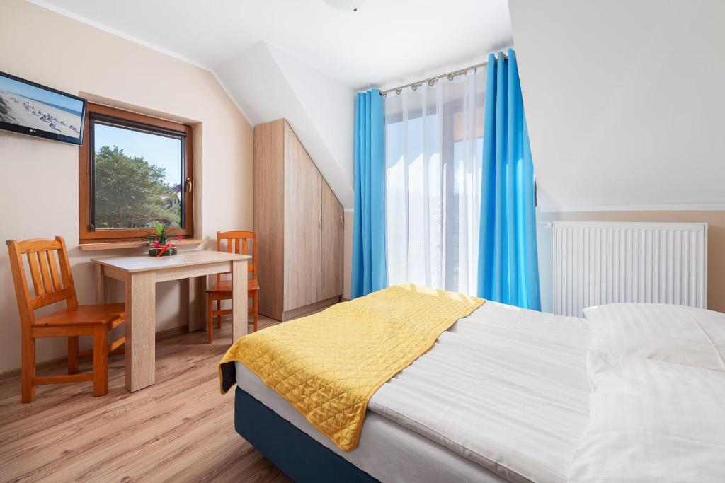 ヤストシェンビャ・グラにあるWilla Octaviaのベッドルーム1室(ベッド1台、テーブル、窓付)