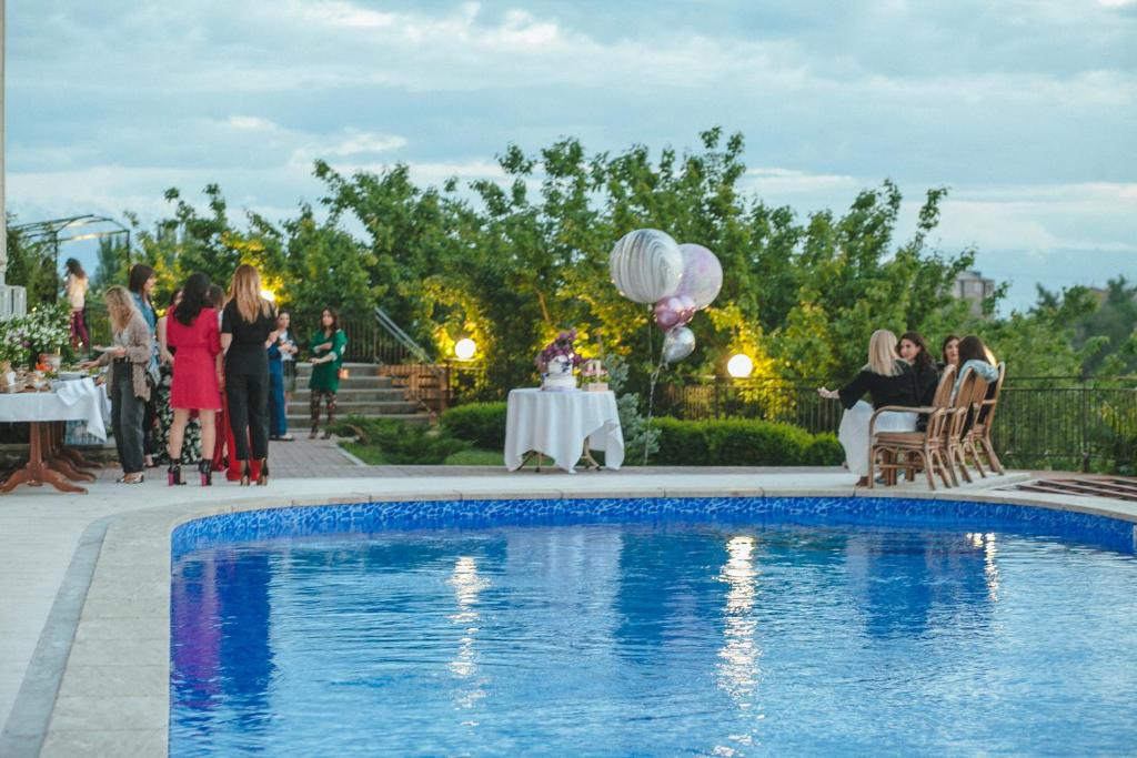 un grupo de personas de pie alrededor de una piscina en Olympia Garden Hotel, en Ereván