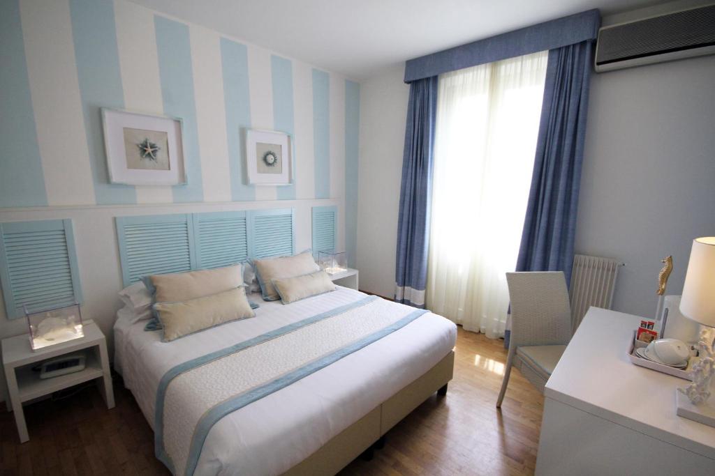 a bedroom with a bed with blue and white stripes at Raffaelli Villino Limoni in Forte dei Marmi