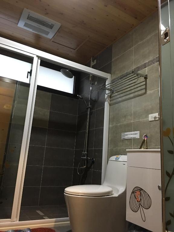 a bathroom with a toilet and a shower at Sweetlight B&amp;B in Jiaoxi