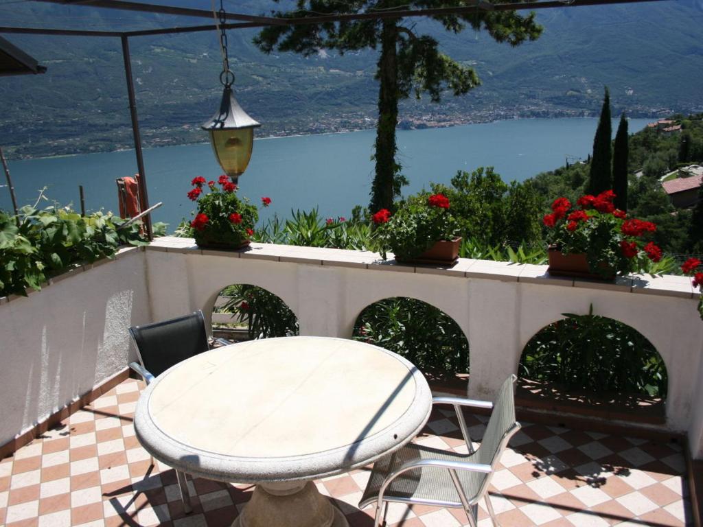 een tafel en stoelen op een patio met uitzicht op het water bij Apartment Imma in Tremosine Sul Garda