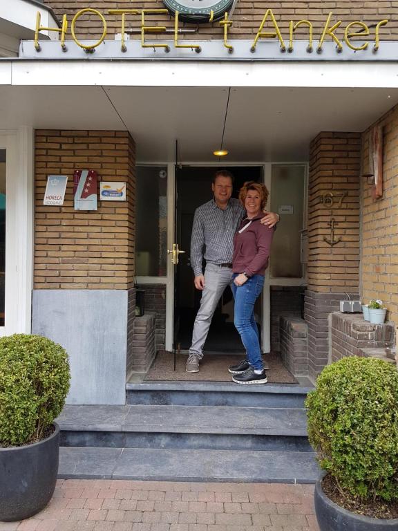 mężczyzna i kobieta stojący na schodach budynku w obiekcie Hotel het Anker w mieście Valkenburg
